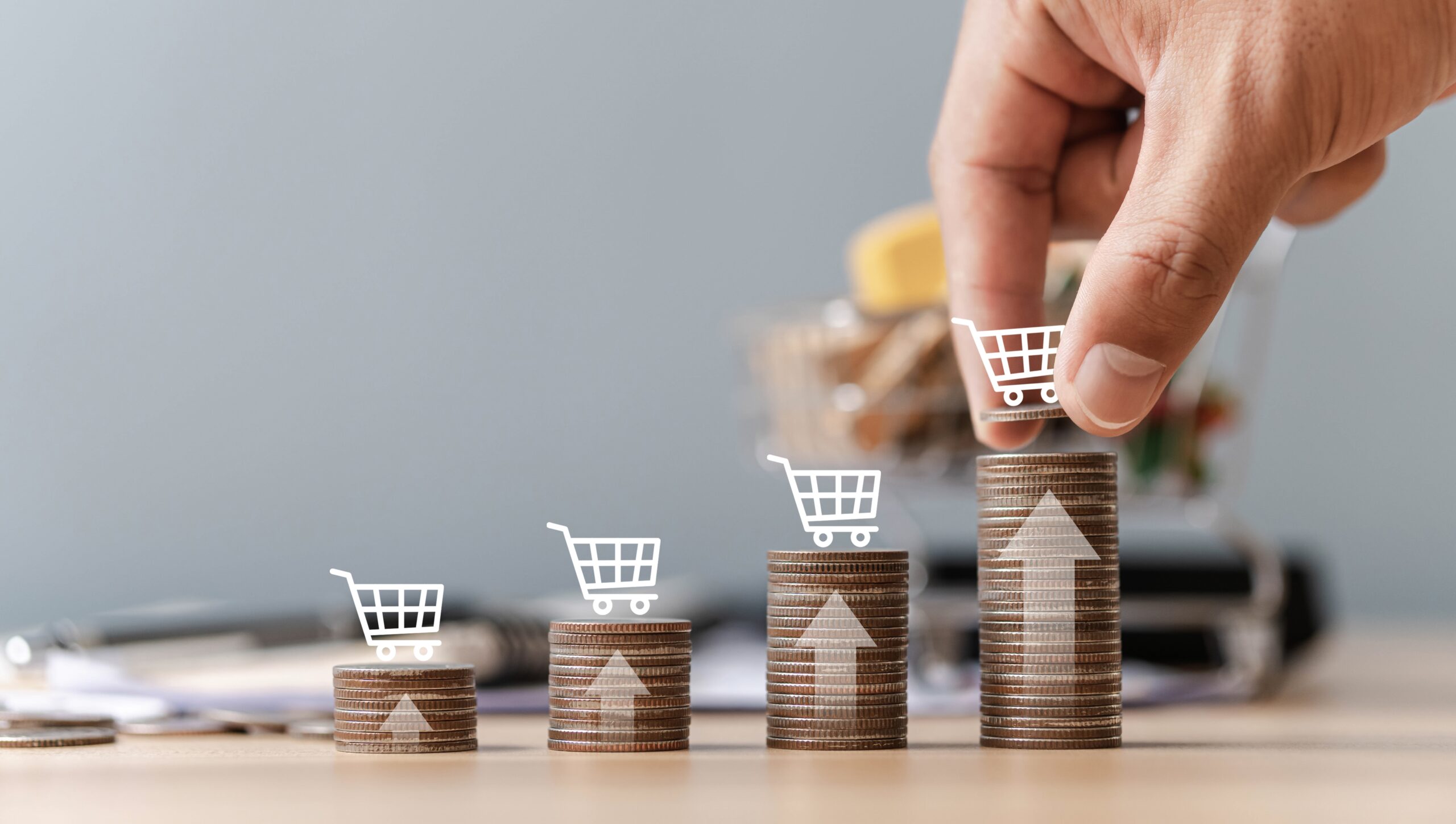 Hand stacking coins with upward trend and shopping carts.